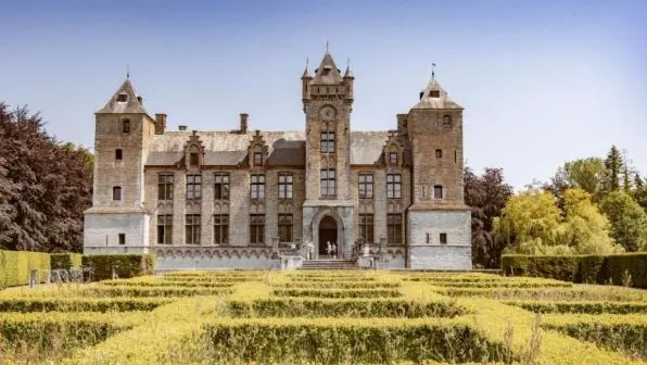 a Flemish castle with a formal box-hedge garden